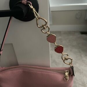 Bag strap extender gold tone with strawberries.